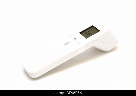 Digital infrared forehead thermometer measuring temperature isolated on white background. Stock Photo