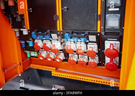 Electrical power distribution board equipped with multi-pin industrial sockets, protective covers, and terminal connection assemblies for site power s Stock Photo