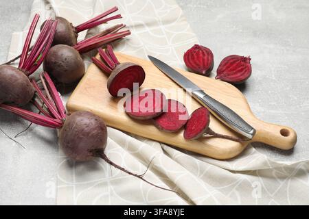 Fresh young beets and knife on gray textured table, closeup Stock Photo