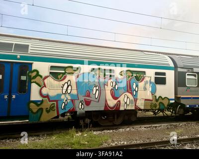 Colorful spray paint graffiti on Trenitalia train car at Firenze SMN station Stock Photo