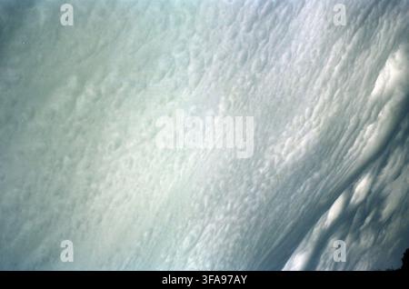 A sweeping expanse of textured altocumulus clouds fills the sky in a dramatic diagonal composition, creating a rippled, mackerel-like pattern in cool Stock Photo