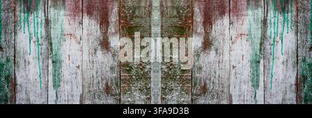 Old wooden fence background with distressed peeling paint and turquoise paint drips forming a symmetrical banner texture. Concept of coating adhesion Stock Photo
