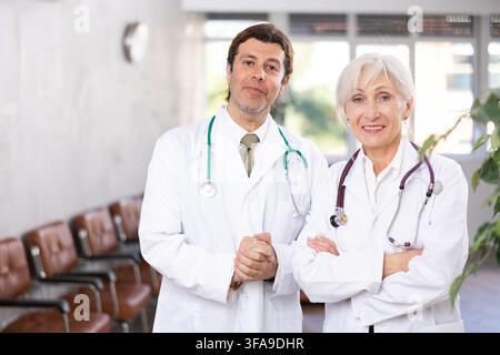 Two experienced professional doctors standing in medical office Stock Photo
