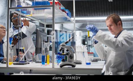 Researcher in clinical laboratory prepares solution with pipette and jars, mixing matter for genetics research and molecular analysis in biotechnology. Conducting advanced research study. Stock Photo