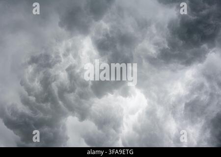Thick turbulent grey clouds filling the sky during a severe weather event or approaching thunderstorm. Stock Photo
