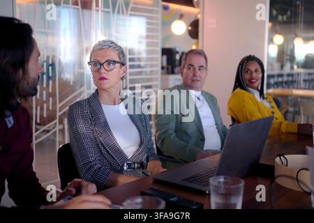 Diverse business team collaborating on project in modern office Stock Photo