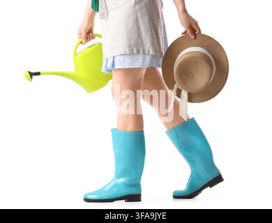 Gardening and outdoor hobby concept, woman in rubber boots holding watering can and straw hat on white background Stock Photo