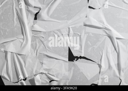 Urban decay and grunge texture, torn white paper posters on a wall, abstract background with ripped and wrinkled layers Stock Photo