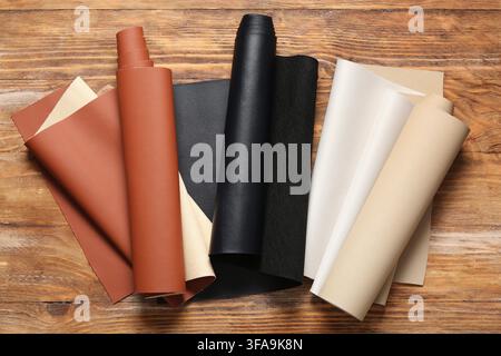 Leatherette and faux leather rolls for upholstery and crafting, material samples on a rustic wooden background Stock Photo