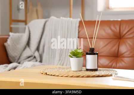 Home comfort and relaxation, reed diffuser with houseplant on a coffee table in a cozy living room interior Stock Photo