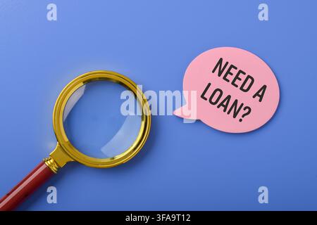 Need a loan message with magnifying glass on blue background. Concept for personal finance, lending services, borrowing money, credit applications, ba Stock Photo