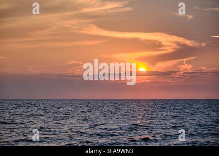 red twilight sky of sunset scene with cloudy sky over the open ocean with many waves Stock Photo