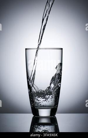 puring refreshment freshness drinking water on clean transperence glass in studio back light Stock Photo