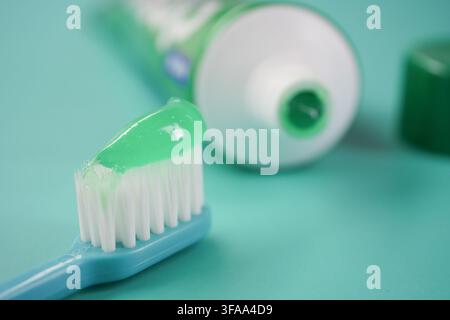 Toothbrush with green toothpaste on blue background Stock Photo