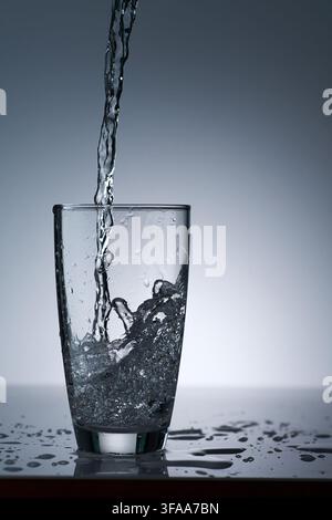 puring refreshment freshness drinking water on clean transperence glass in studio back light Stock Photo