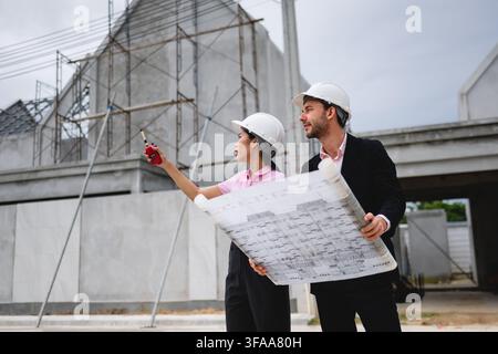 Engineers team discussion inspection at house construction site reveals a mix of modern architectural structures in progress Stock Photo