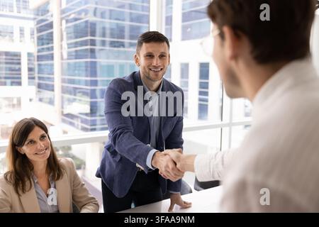 HR manager greeting professional candidate with handshake after successful interview Stock Photo