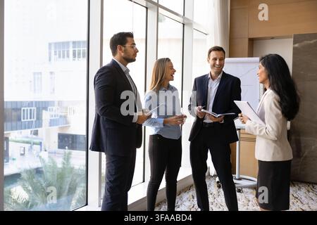 Multiethnic businesspeople collaborating on project strategy during office meeting Stock Photo