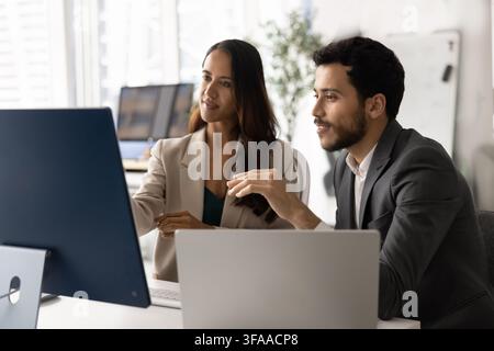 Diverse coworkers collaborating on strategy using computer in office Stock Photo