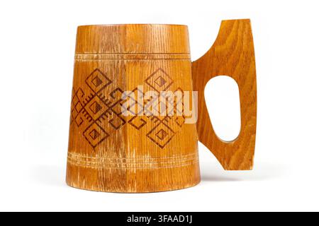 An old wooden mug with ornament. Wooden mug on a white background. Stock Photo