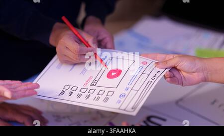 UX UI designer hands pointing at paper wireframe sketch for app layout Stock Photo