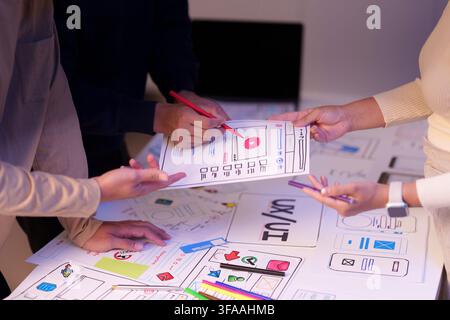 UX UI design team collaborating on mobile app wireframe sketches in meeting Stock Photo