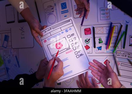 Creative UX UI design team reviewing video app wireframe prototype on paper Stock Photo