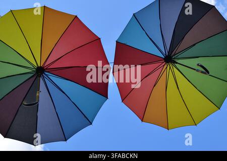 Decorative colorful umbrellas against bright blue sky. Stock Photo