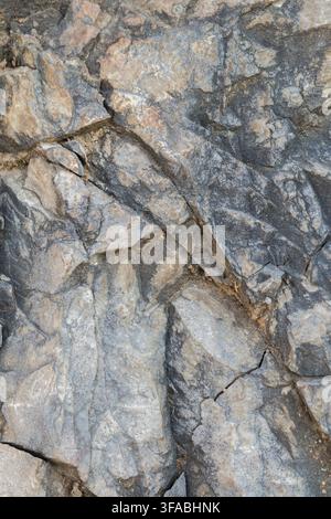 Rocky surface with natural cracks and layered geological texture. Stock Photo