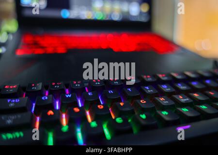 A gaming laptop with colorful backlit keyboard creating vibrant computer workspace with shallow focus and glowing lights Stock Photo
