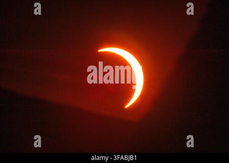 Aerial view of a partial solar eclipse showing the crescent sun glowing against the dark sky over Salisbury, Wiltshire, United Kingdom. Stock Photo