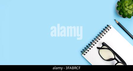 Workspace with notepad, pencil and glasses. Flatlay composition. Top view. Banner. Place for your text. Stock Photo
