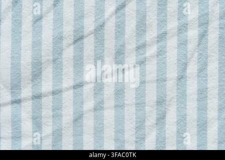 Light Blue And White Striped Textile With Soft Diagonal Folds Filling Frame, Showing Woven Fabric Surface, Repeating Vertical Bands And Gentle Draped Texture In Close View. Stock Photo
