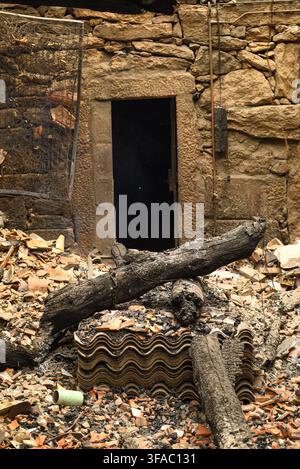 Insurance concept shot showing destroyed home rubble with burnt wooden timber and broken tiles Stock Photo
