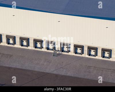 Aerial view of a modern warehouse facility with multiple loading docks and bays for freight logistics in Genk, Flanders, Belgium. Stock Photo
