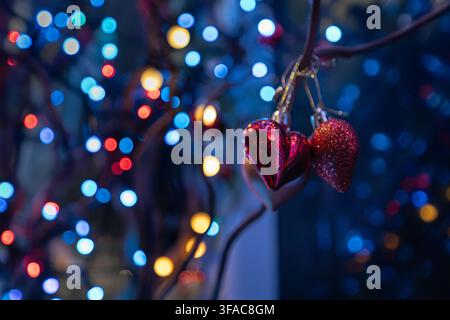Creative shallow depth of field composition featuring hanging heart ornament and festive light bokeh Stock Photo