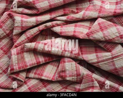 A wrinkled and folded fabric with a pink and white plaid pattern Stock Photo