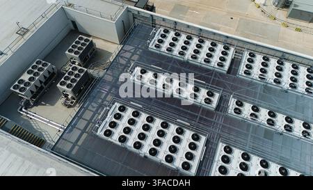 Aerial view of multiple industrial ventilation cooling units, heat exchangers, and HVAC fans arranged in rows on a flat commercial rooftop in Luton, E Stock Photo