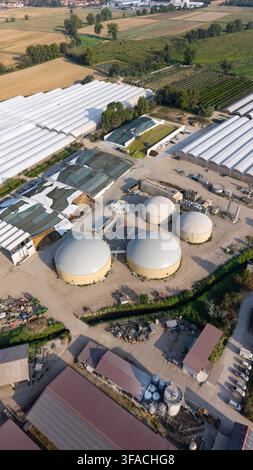 Aerial view of large greenhouses with a circular water tank and solar ...