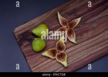 Fresh figs whole and sliced on a wooden serving board Stock Photo