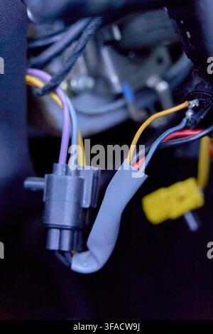 Interlocking electrical networks and complex vehicle architecture, exposed colorful wires and plastic connectors inside an automobile steering column Stock Photo