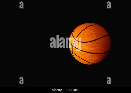 Basketball on solid black background with dramatic lighting and copy space Stock Photo
