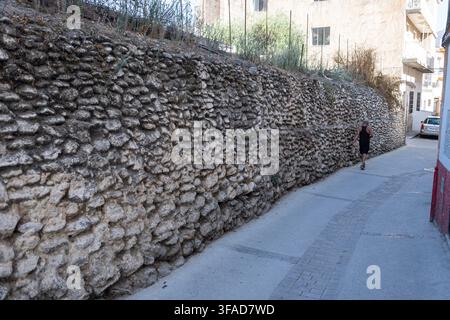 Traditional dry stone wall beside a narrow lane in Órgiva, Las Alpujarras, Granada province, Andalusia, Spain. Stock Photo