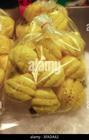 Peeled Phulae pineapple from Chiang Rai, Thailand, in a plastic bag on ice Stock Photo