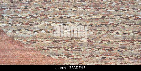 Huge old brick wall made of many bricks in various colors Stock Photo