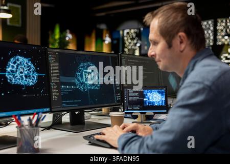 Man utilizing artificial intelligence on computer to optimize performance and forecast issues. IT professional in tech company office training deep learning models to perform automatic updates Stock Photo