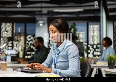 Woman office worker using data and technology for business management, reviewing statement graphs on monitor to create reports and improve efficiency, objectives achievement. Vision. Stock Photo