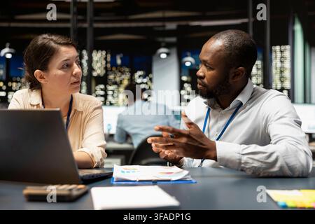 Brainstorming, laptop and team of office clerks completing spreadsheets, analyzing data. Researching information online, notebook and teamworking colleagues browsing internet, working overnight Stock Photo