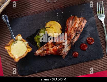 Roast rabbit served with potatoes and braised peppers Stock Photo
