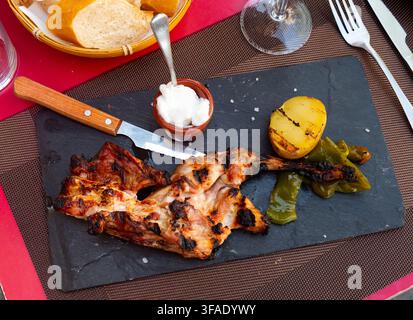 Roast rabbit served with potatoes and braised peppers Stock Photo